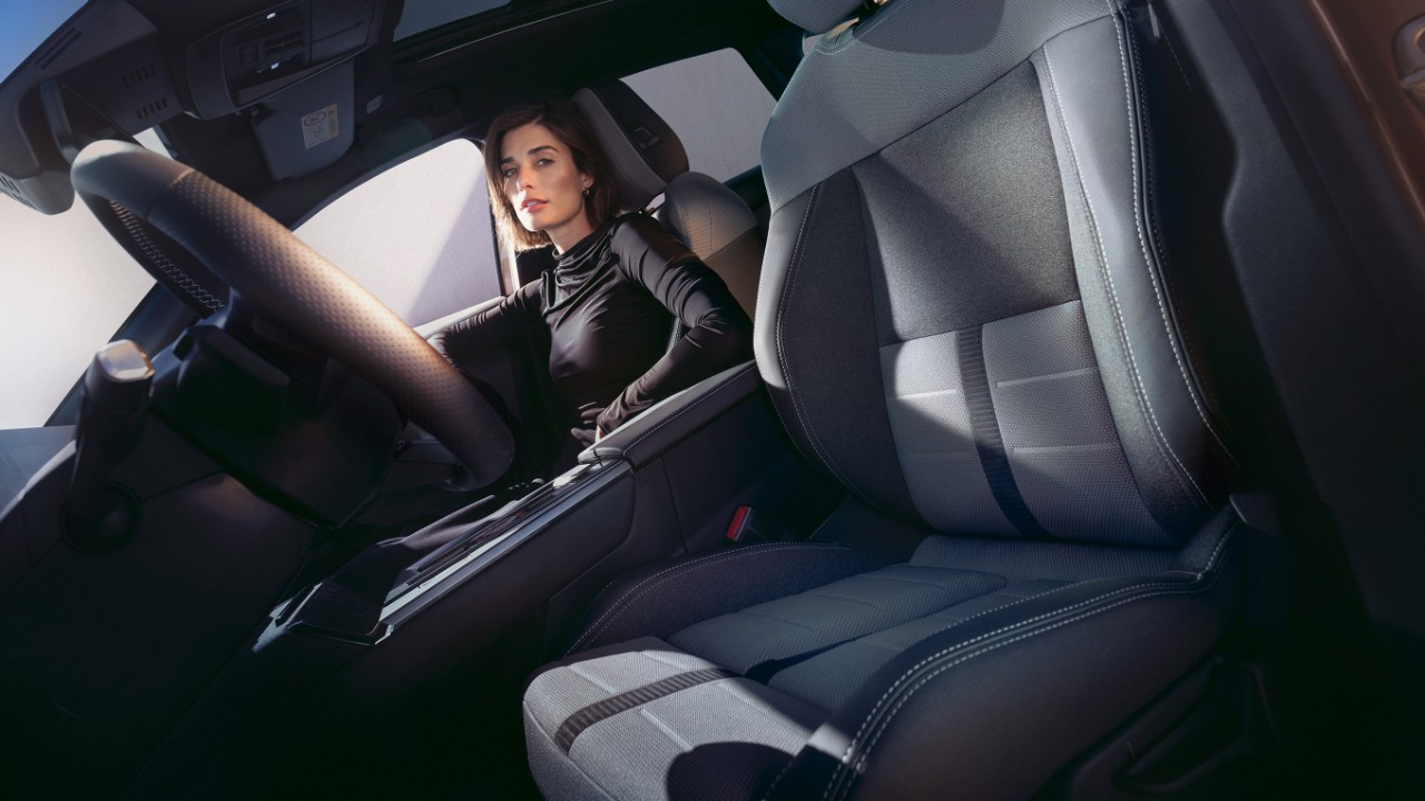 Vista ravvicinata del sedile anteriore del conducente del nuovo Opel Grandland, con una donna seduta sul sedile del passeggero