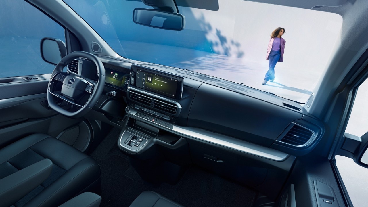  Interior view of a white Opel Zafira  from the passenger seat with woman standing outside